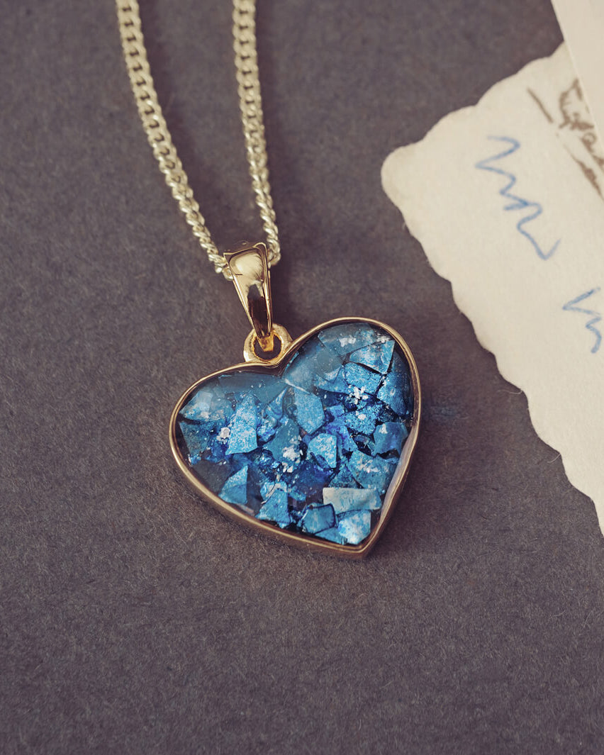gold heart necklace filled with blue crystals, resin and cremation ashes