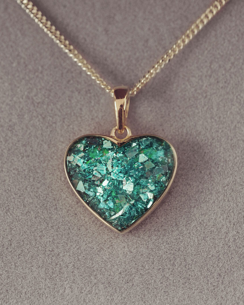 gold heart necklace filled with green crystals, resin and cremation ashes