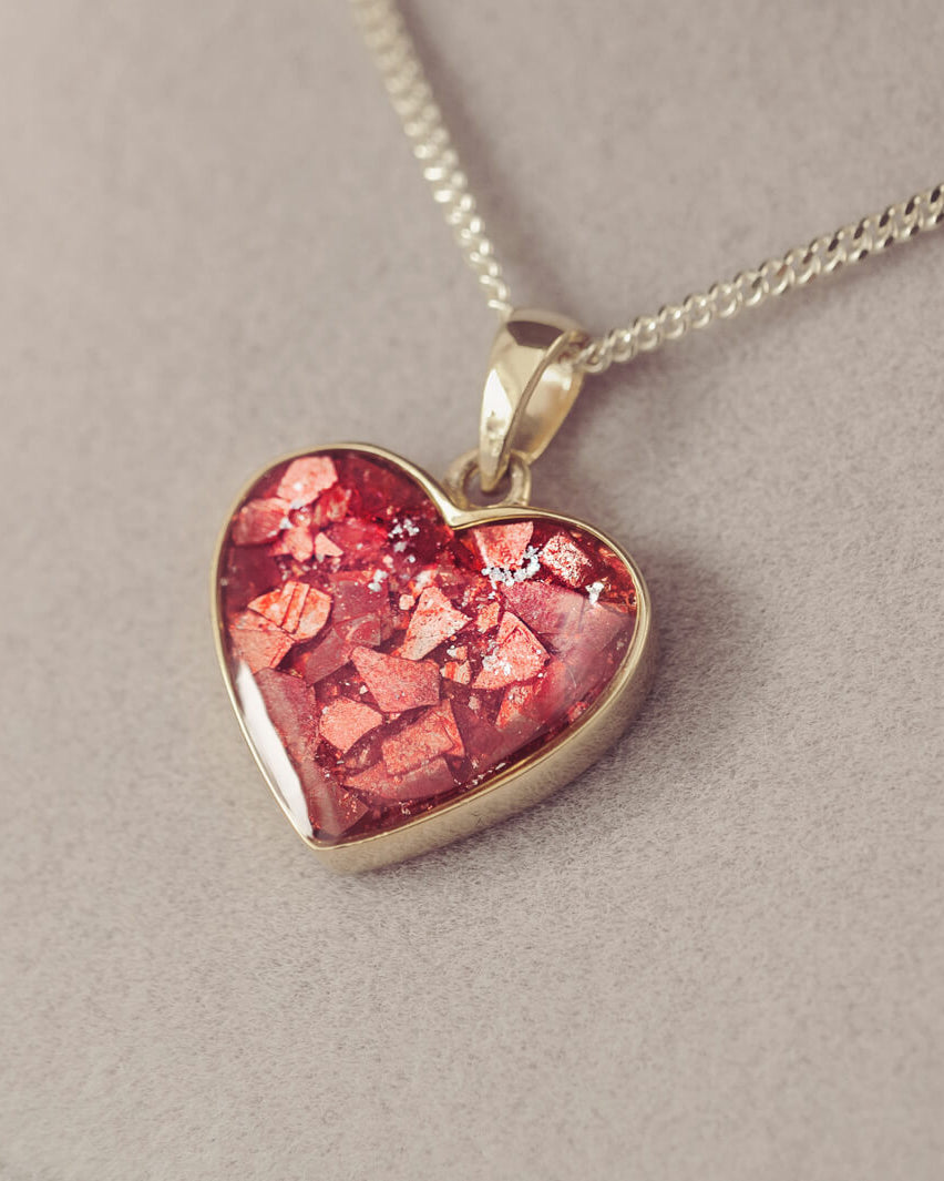 gold heart necklace filled with red crystals, resin and cremation ashes