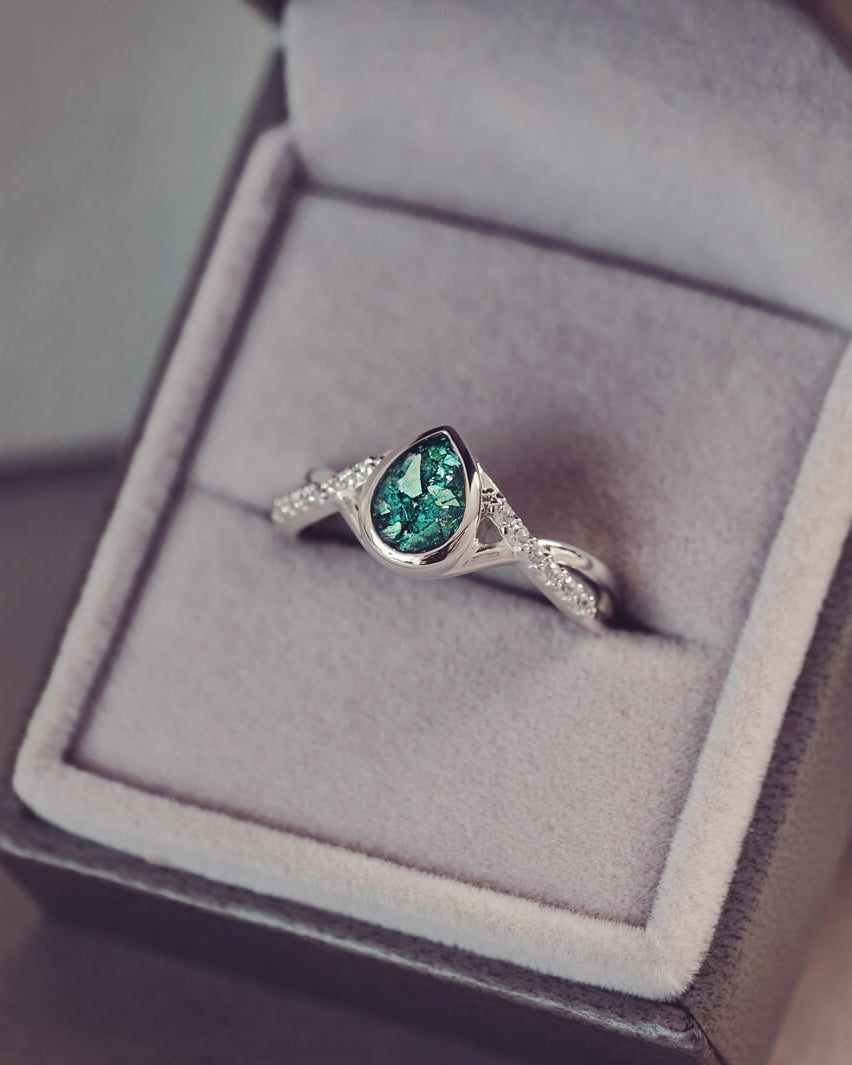 Sterling silver, peardrop shaped ring with a green stone, created using cremation ashes and crystal