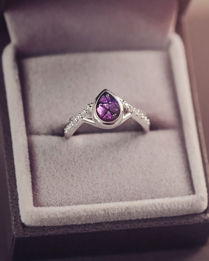 Sterling silver, peardrop shaped ring with a purple stone, created using cremation ashes and crystal