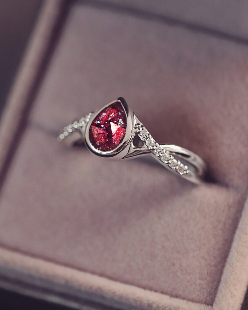 Sterling silver, peardrop shaped ring with a red stone, created using cremation ashes and crystal