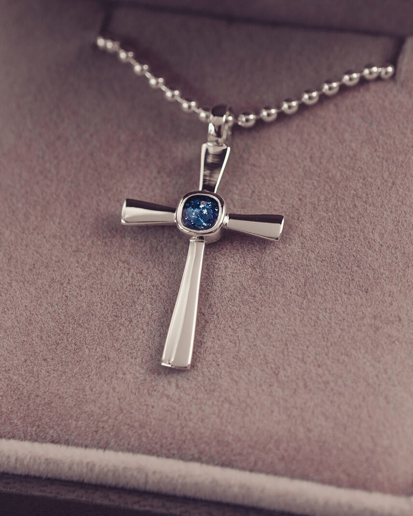silver cross necklace holding cremation ashes, resin and blue crystal