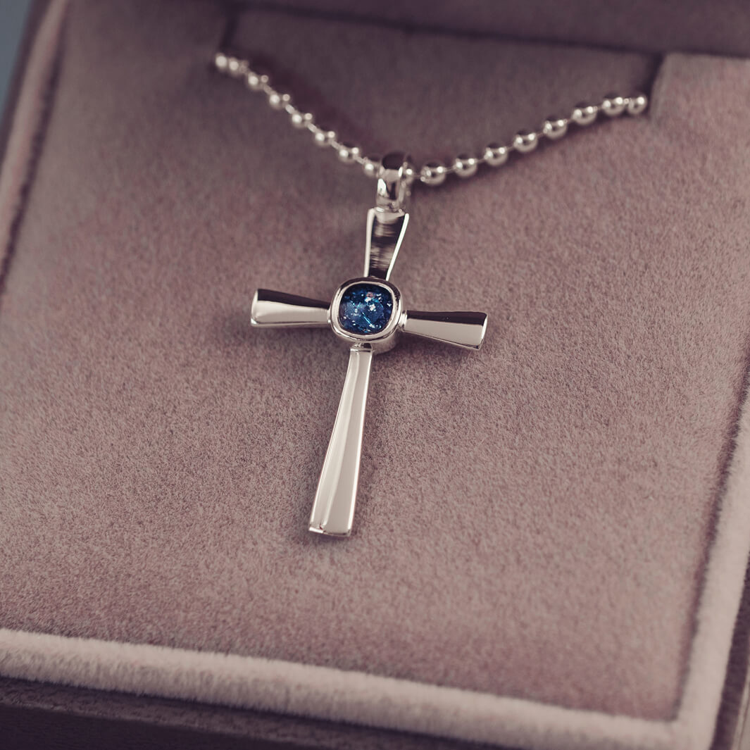 silver cross necklace holding cremation ashes, resin and blue crystal