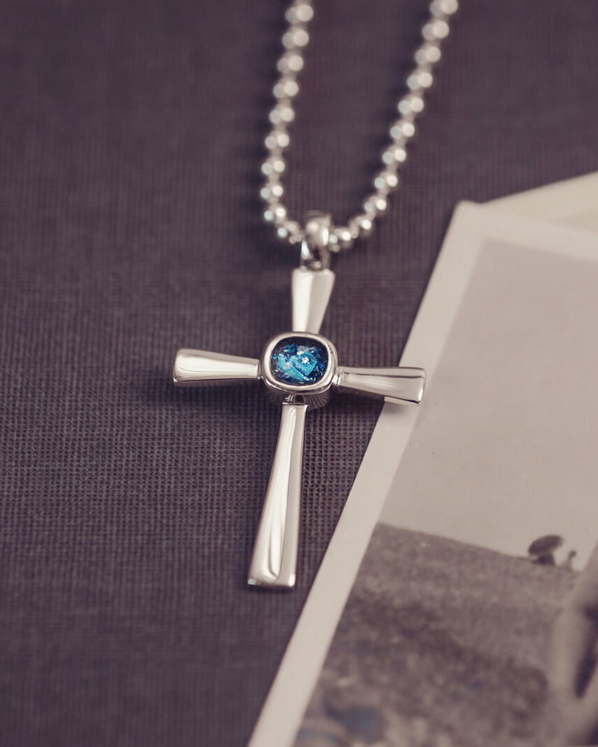 silver cross necklace holding cremation ashes, resin and blue crystal