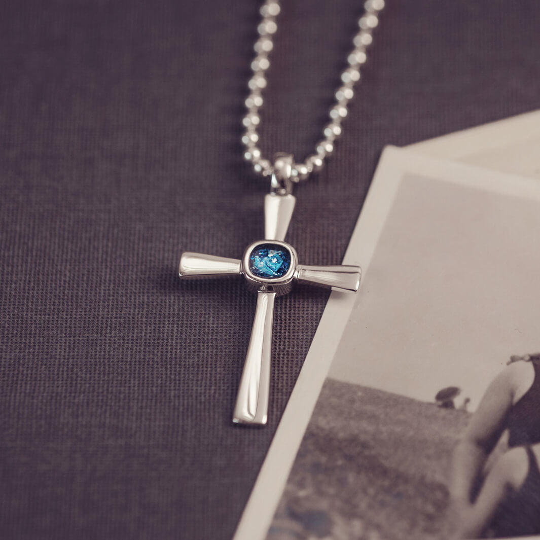 silver cross necklace holding cremation ashes, resin and blue crystal