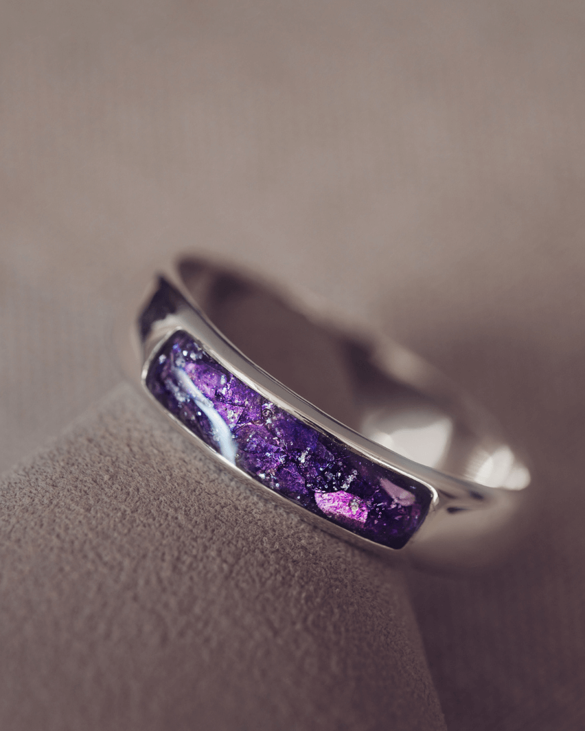 Sterling silver Mens Band Ring with a central section filled with memorial ashes and purple crushed crystals, displayed on a grey background