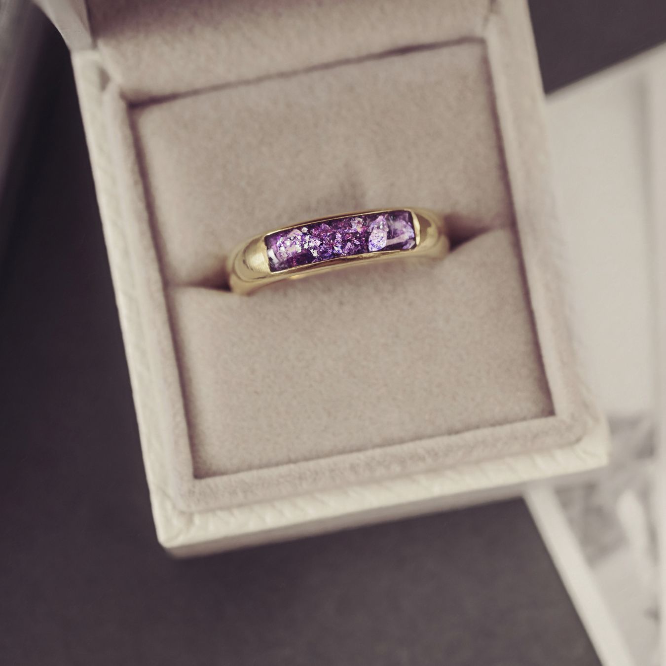Gold ring with purple gemstones in a jewelry box