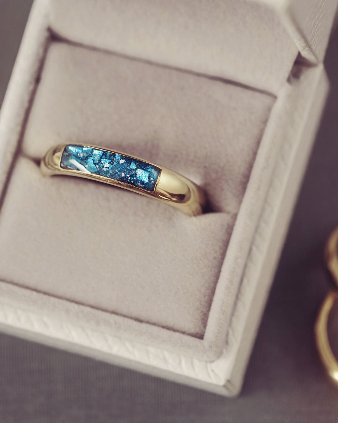 Gold ring with blue gemstones in a jewelry box