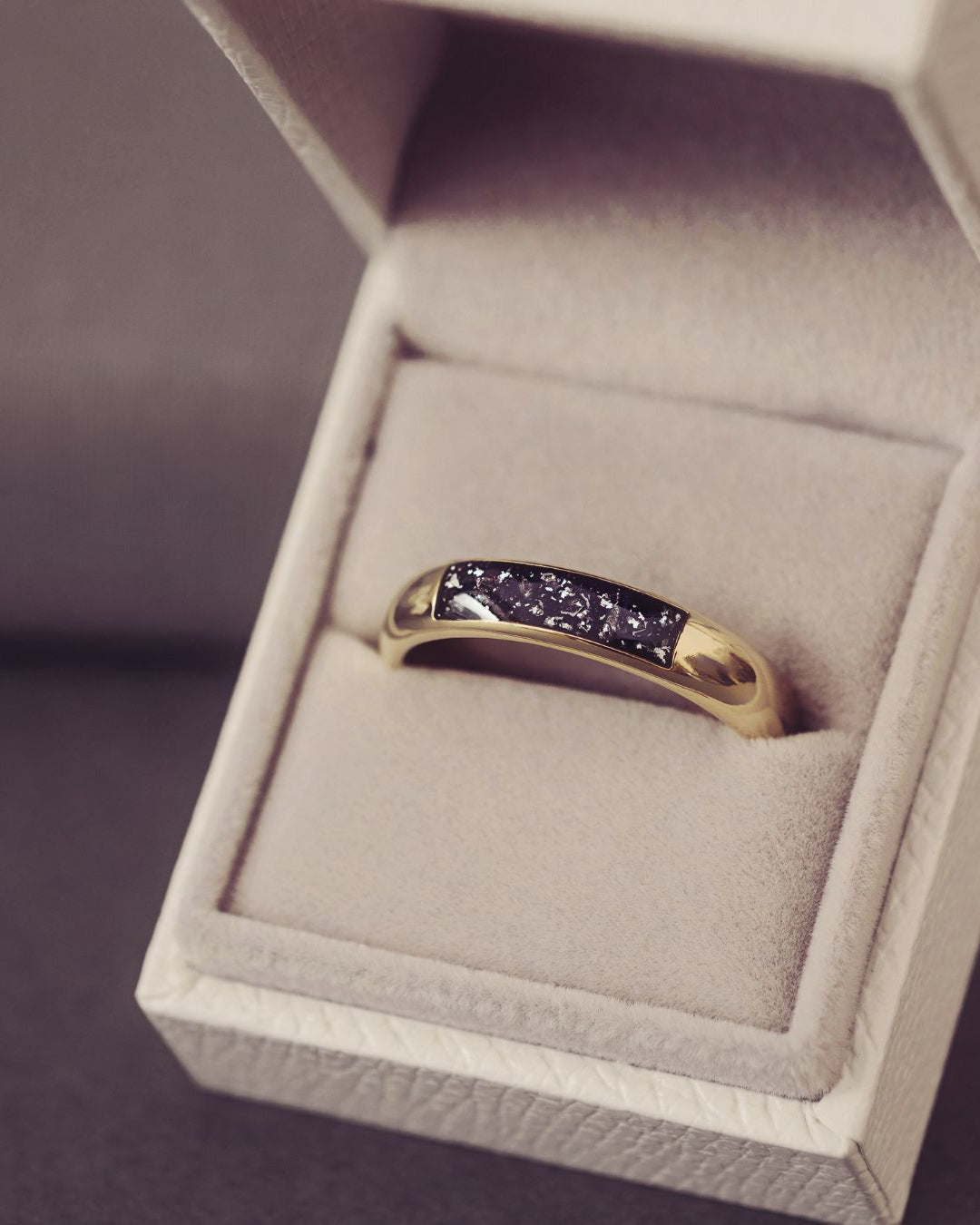 Gold ring with purple gemstones in a jewelry box