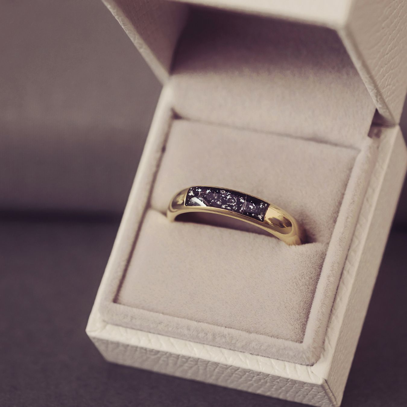 Gold ring with purple gemstones in a jewelry box