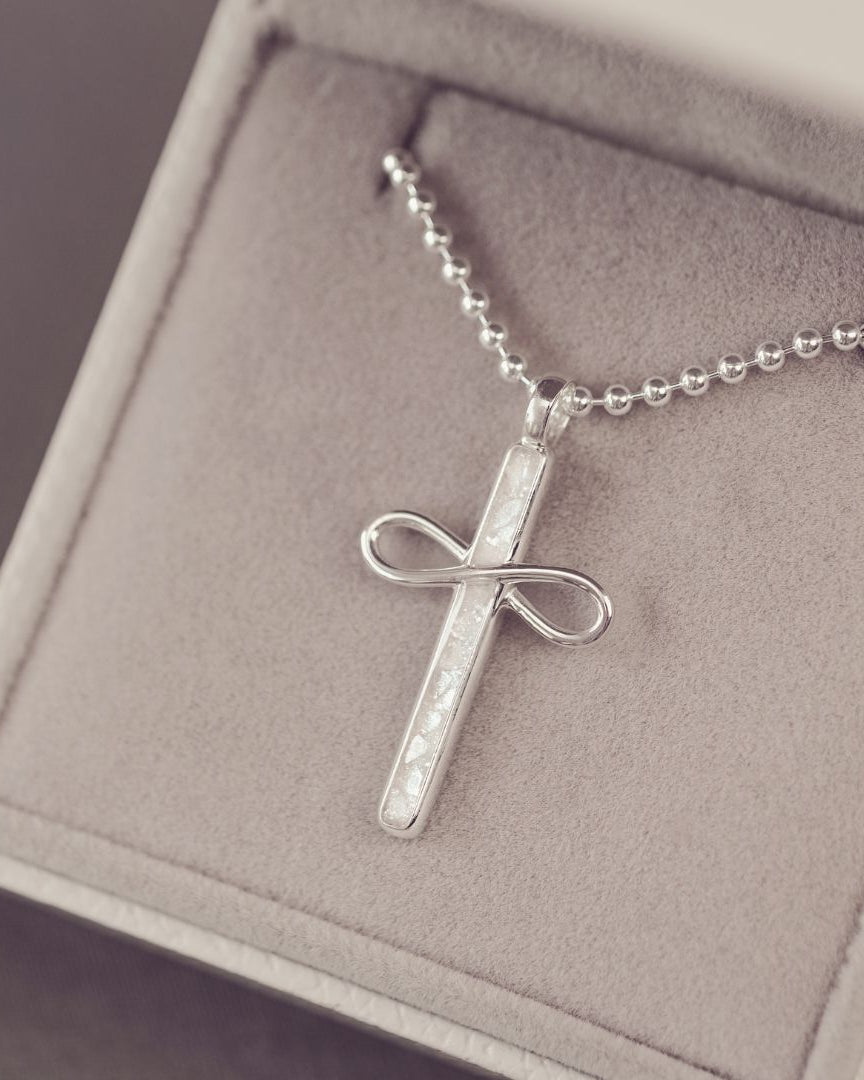 Silver cross pendant necklace on a chain in a jewelry box