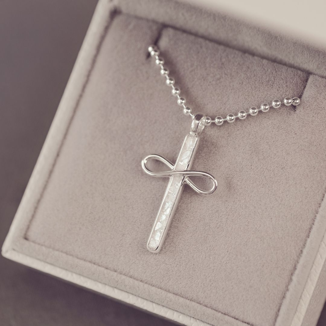 Silver cross pendant necklace on a chain in a jewelry box