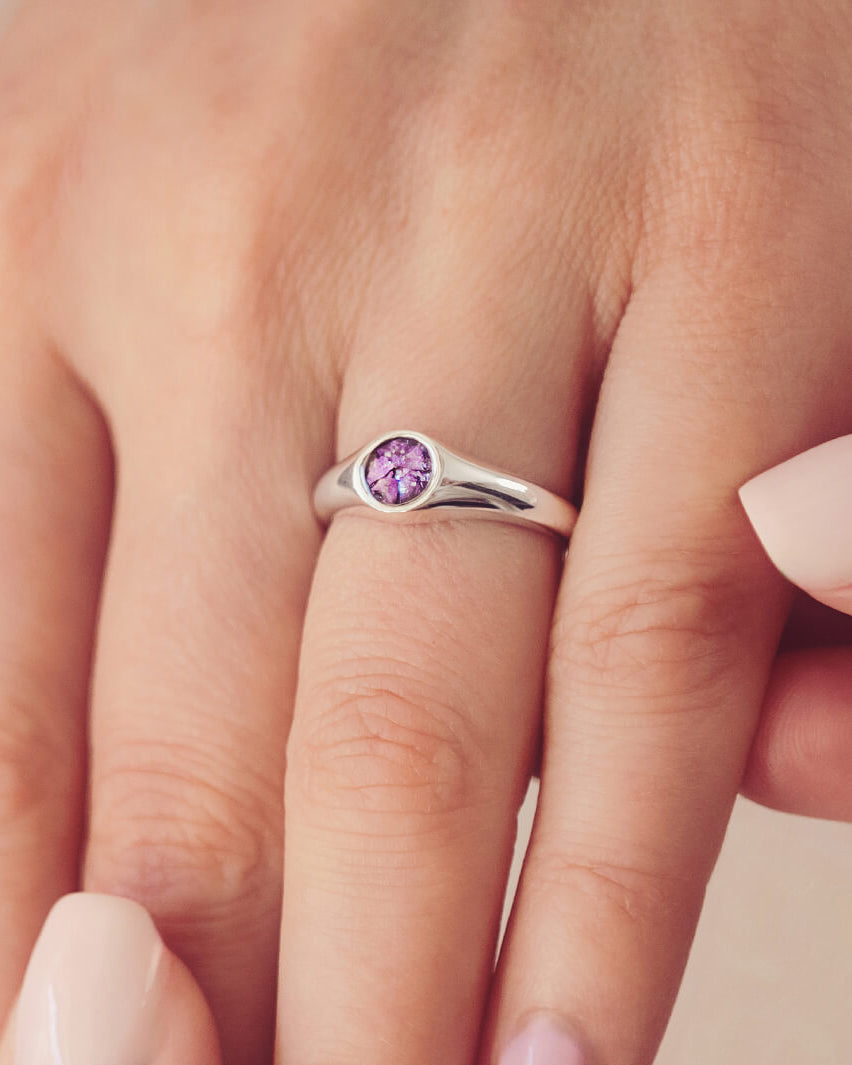 sterling silver ring band with circular stone holding cremation ashes and purple crystal