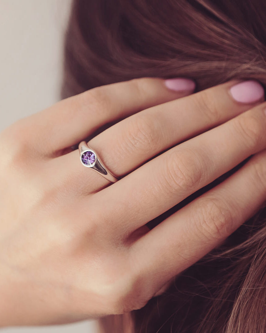 sterling silver ring band with circular stone holding cremation ashes and purple crystal