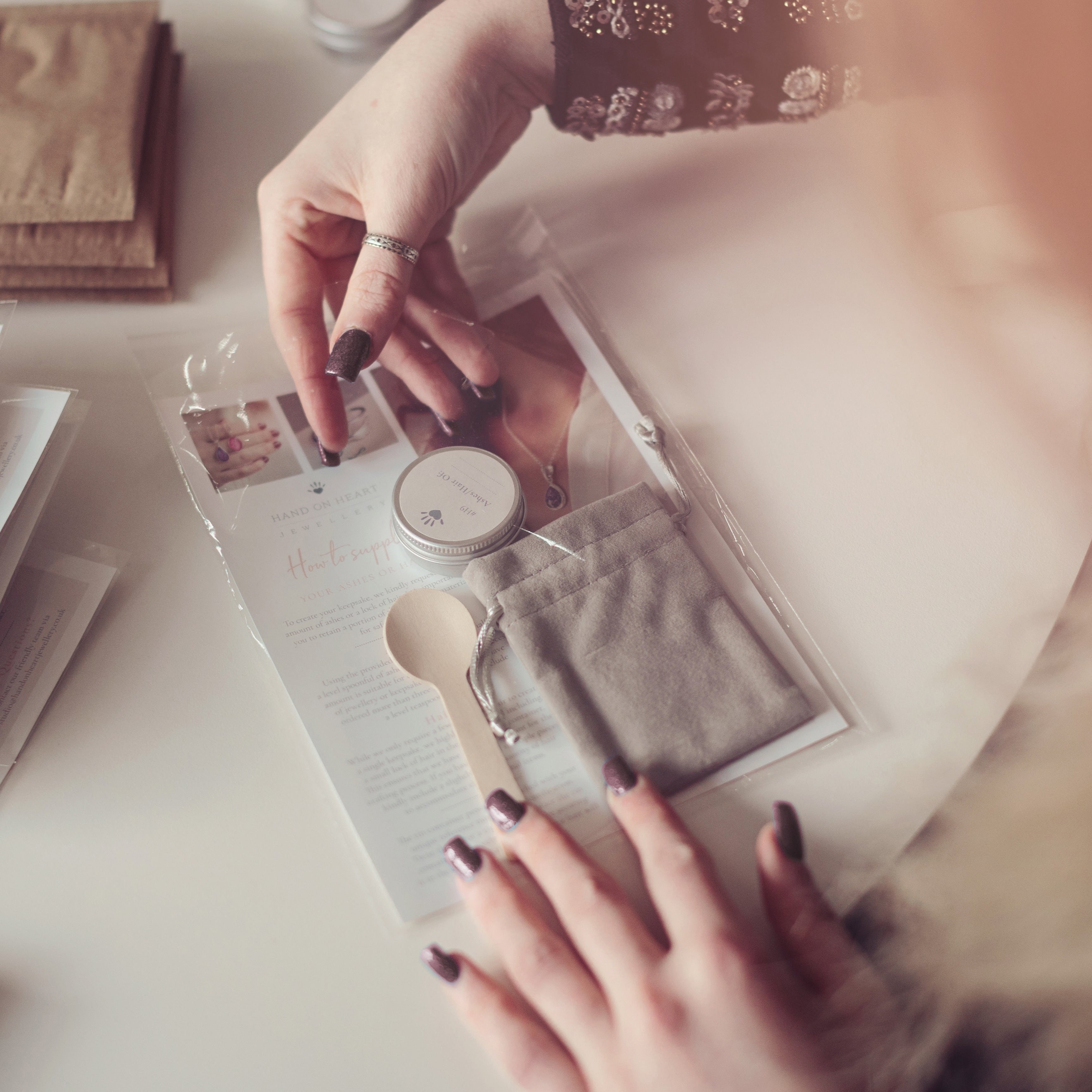 A woman preparing an ashes collection pack containing a tin, spoon, pouch and instructions