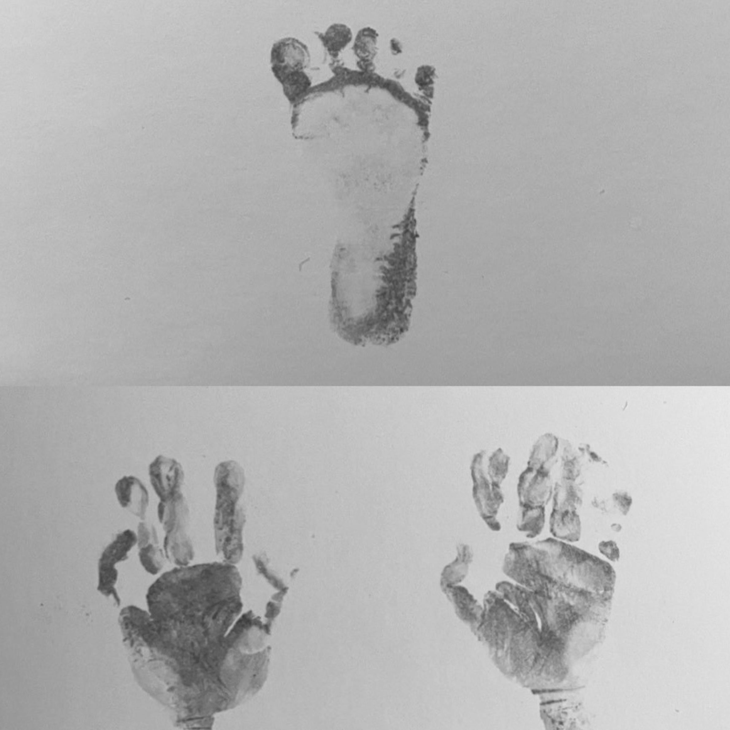 Black and white image. At the top there is a footprint, and underneath is a left and right handprint. 