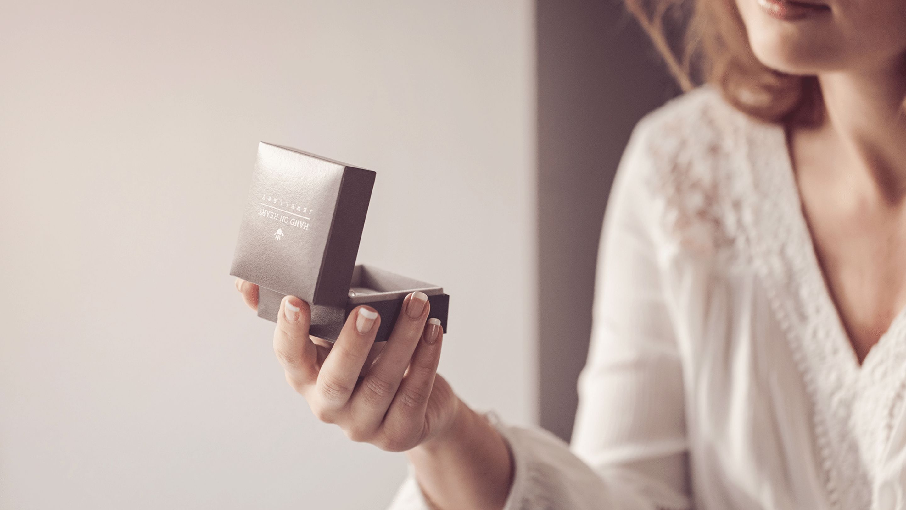 A woman looking at an open Hand on Heart Jewellery Box