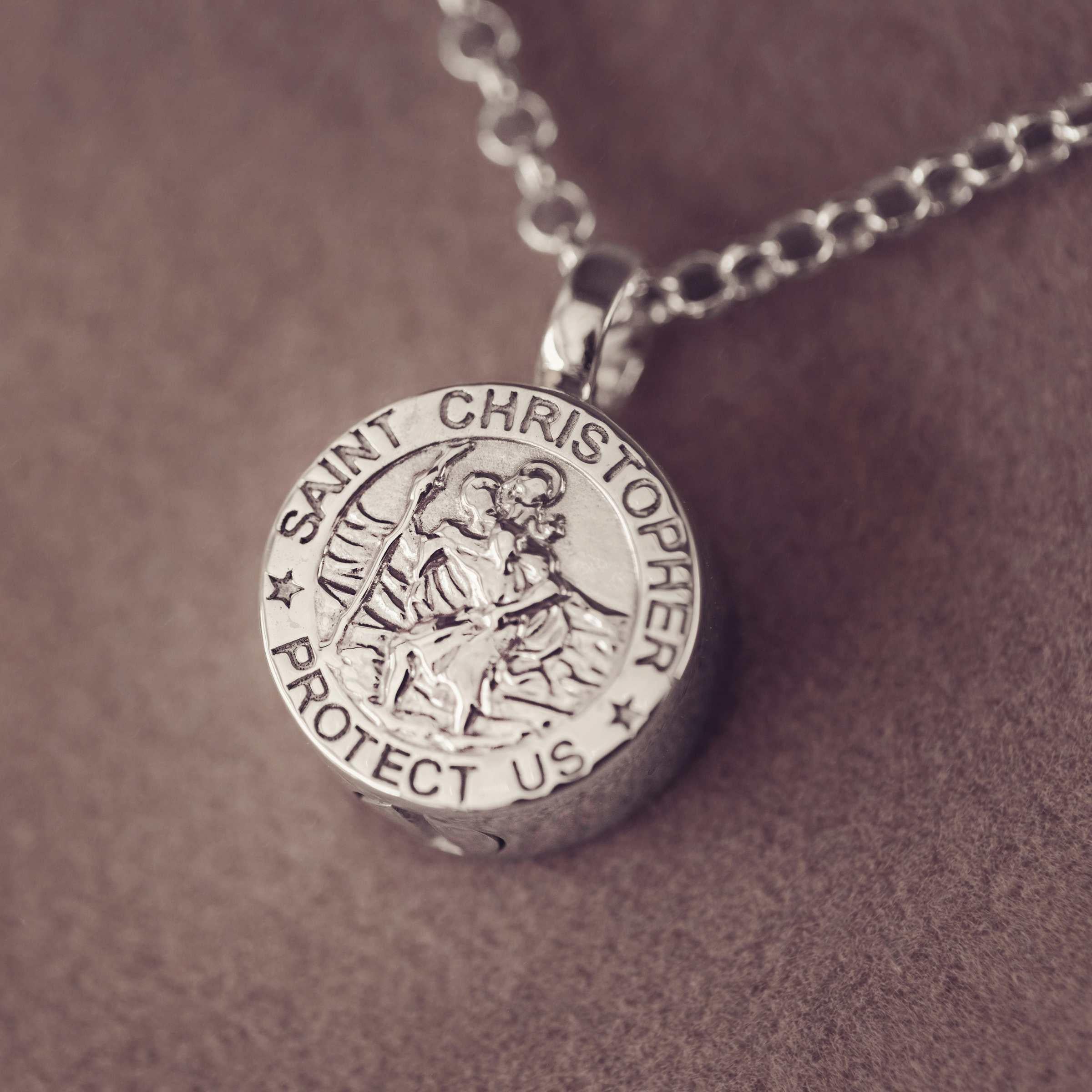 Silver Saint Christopher pendant on a chain against a brown background