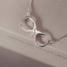 Silver infinity necklace with 'My Love' engraving on a soft background