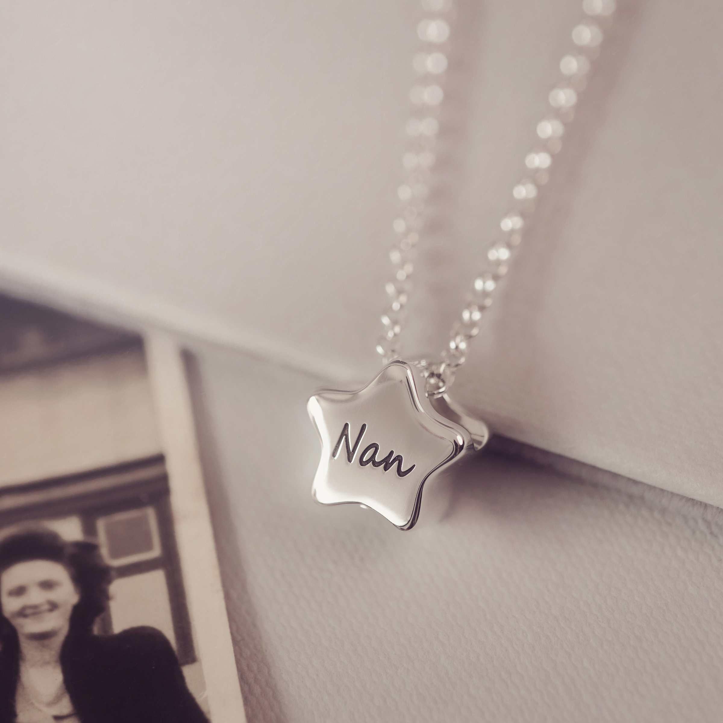 Star-shaped pendant necklace with 'Nan' engraved, hanging against a neutral background.