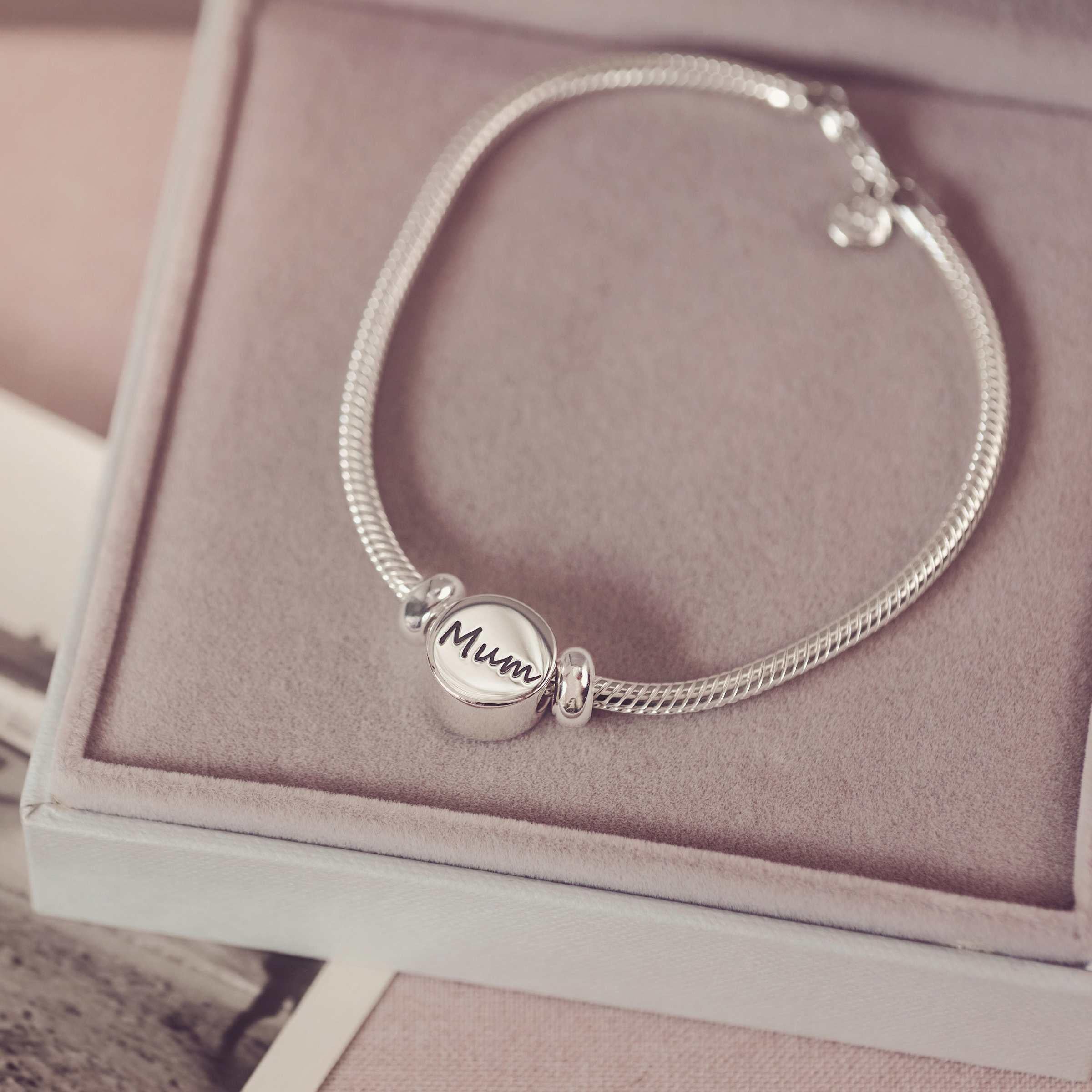 Silver bracelet with a 'Mum' charm on a pink jewelry box