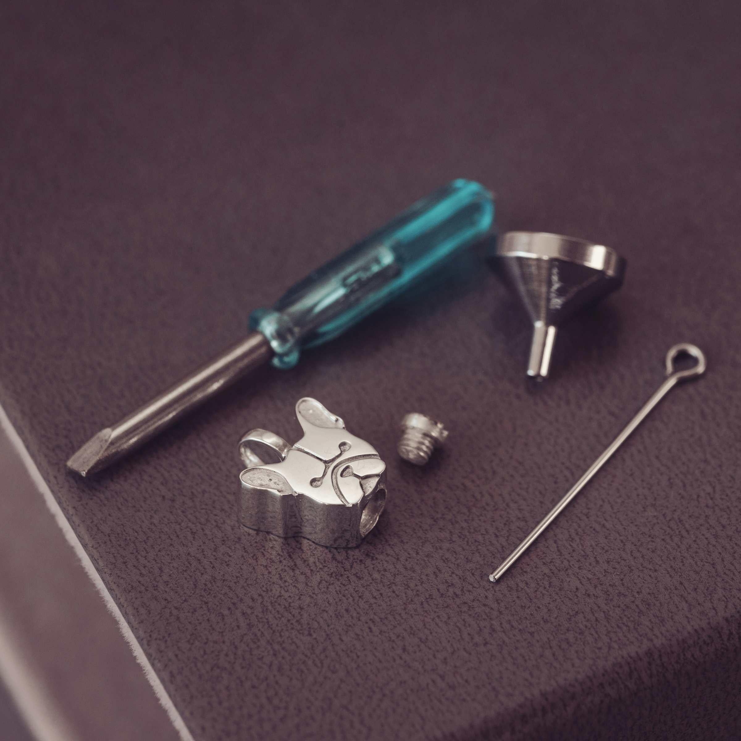 silver jewellery components and tools on a dark background