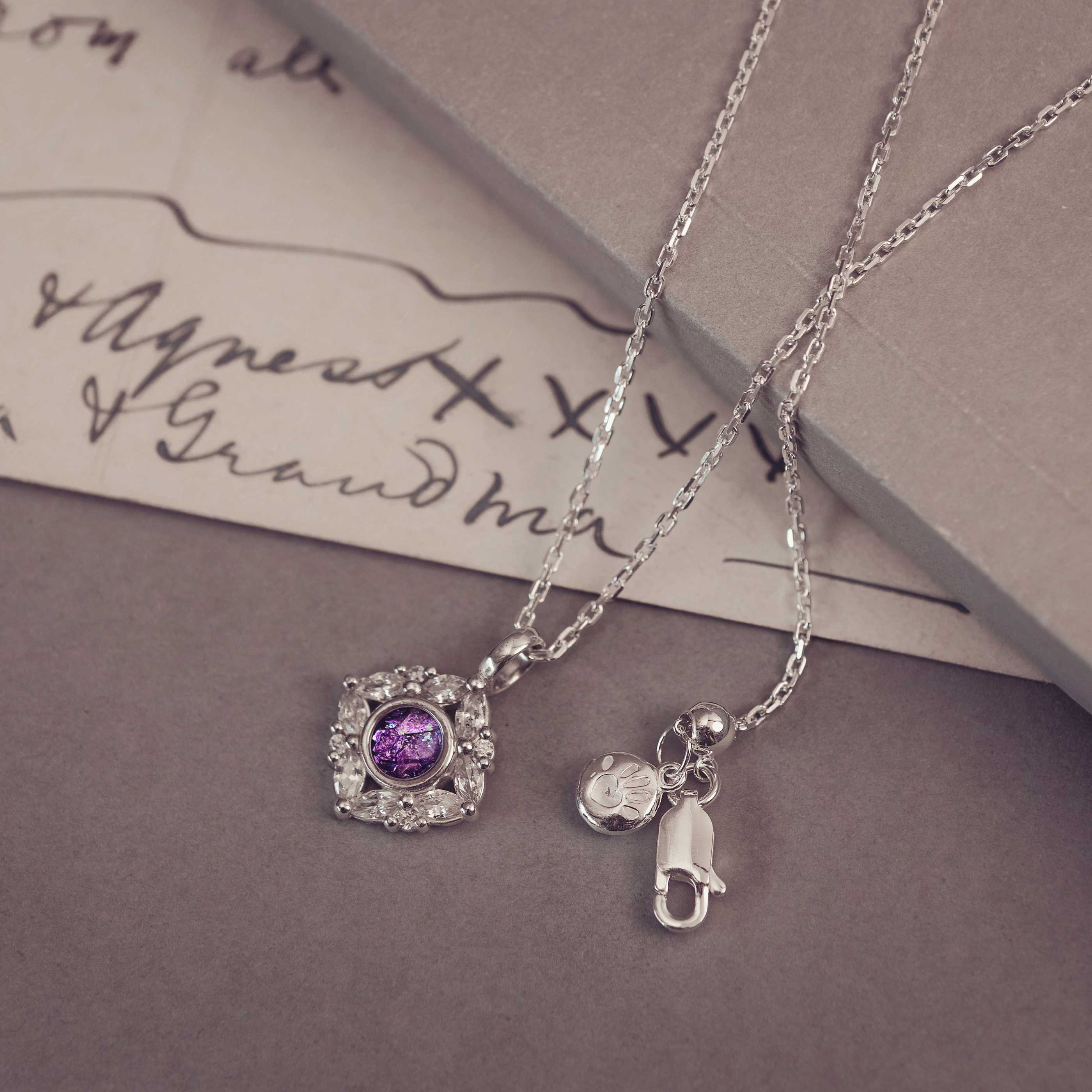 Silver necklaces with charm on a textured surface