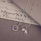 Silver necklaces with charm on a textured surface
