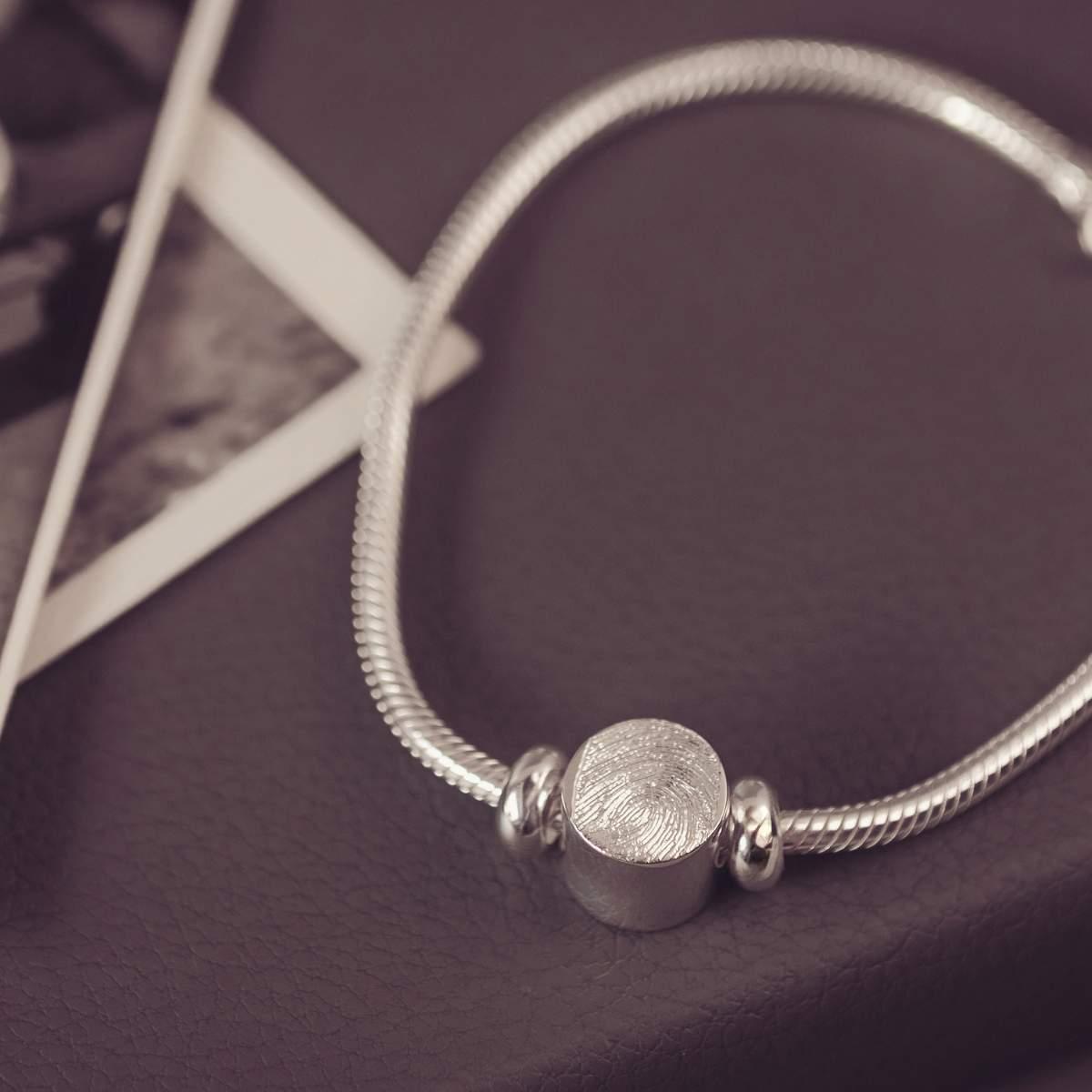 Silver bracelet with a round bead on a dark surface