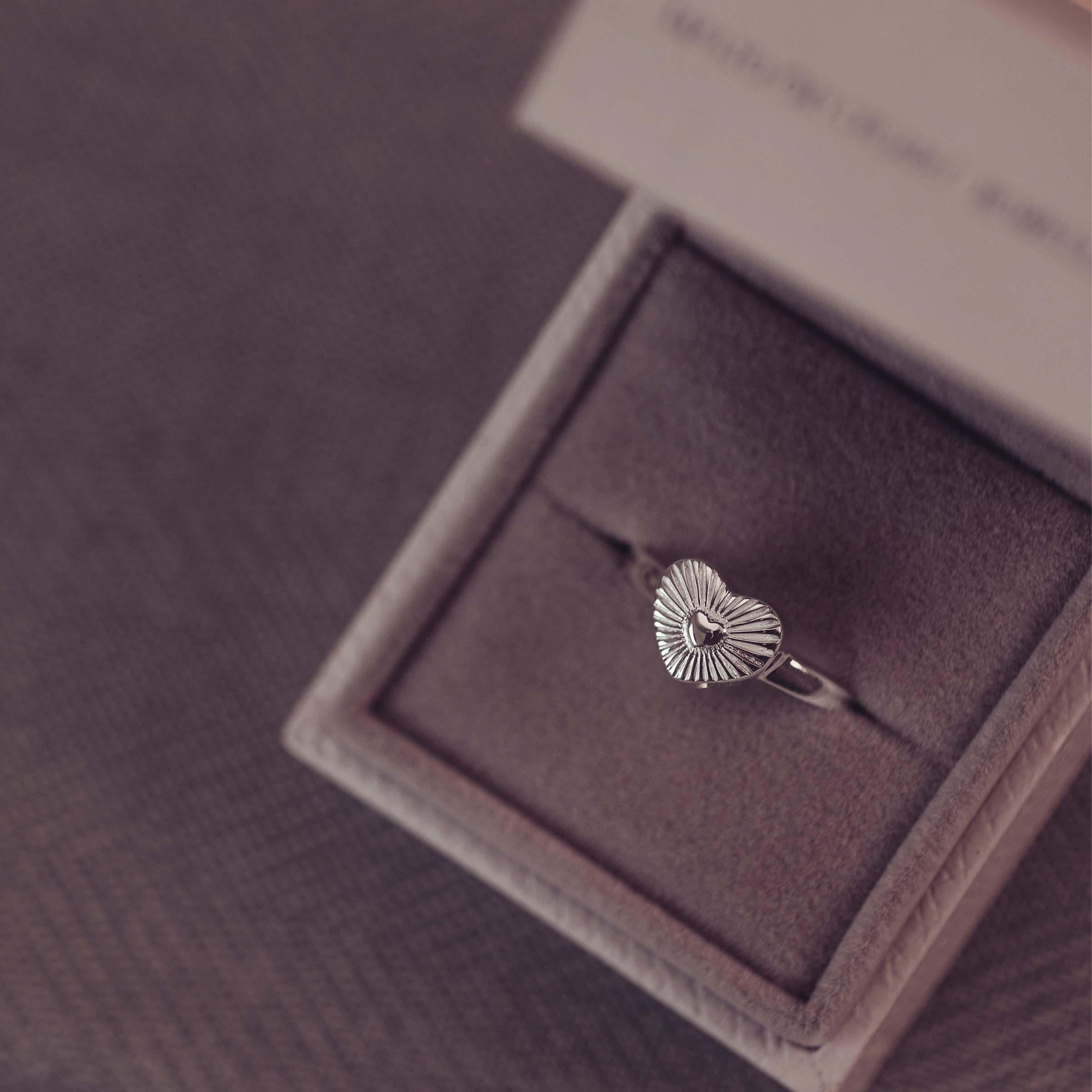 Silver ring in a jewelry box on a textured surface