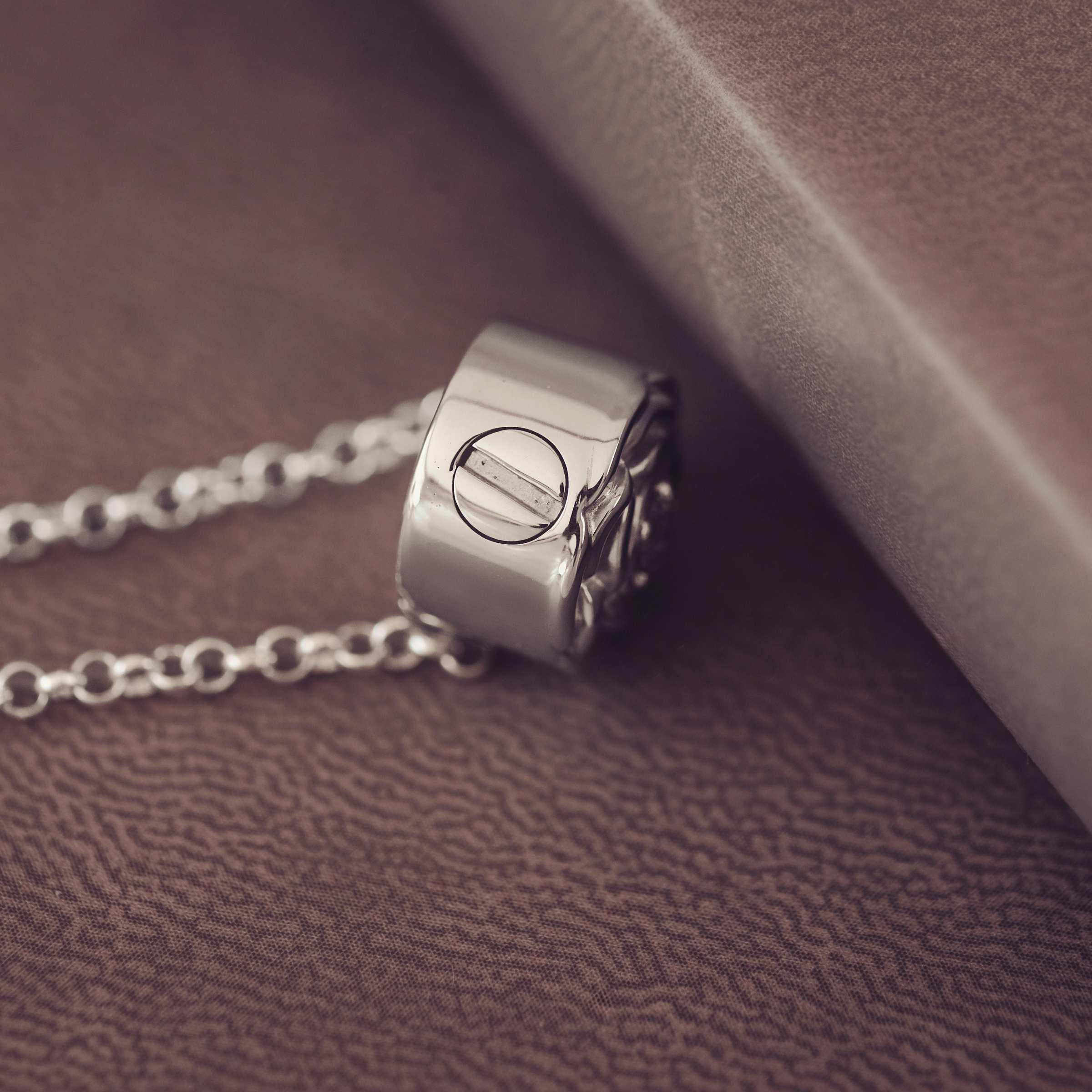 Silver necklace pendant on a textured surface