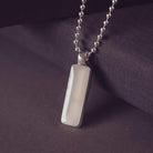 Silver pendant necklace on a dark purple fabric background