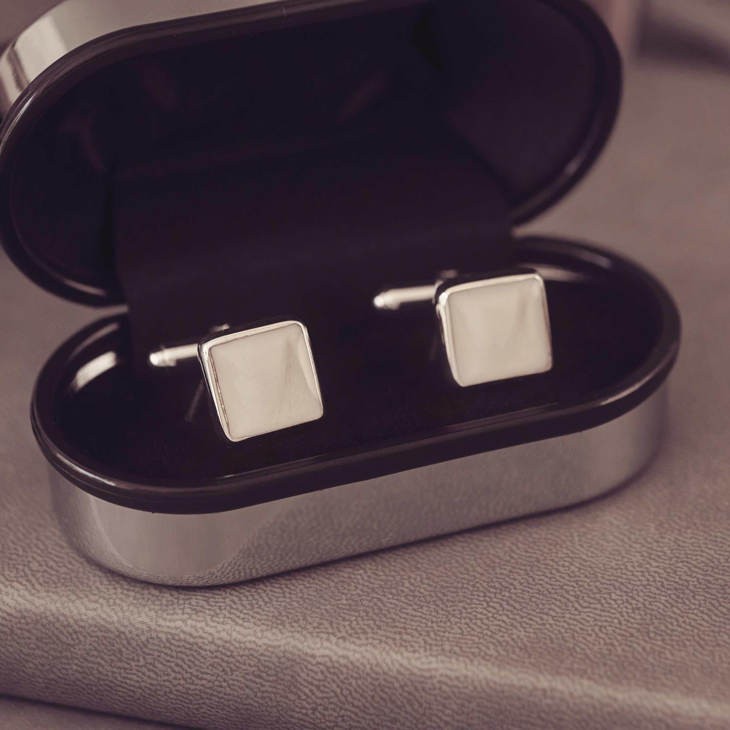 Silver square cufflinks in a silver coloured box.