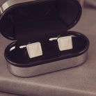 Silver square cufflinks in a silver coloured box.