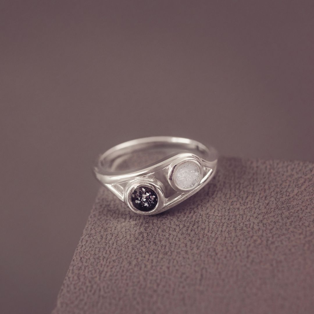 Silver ring with gemstones on a textured surface