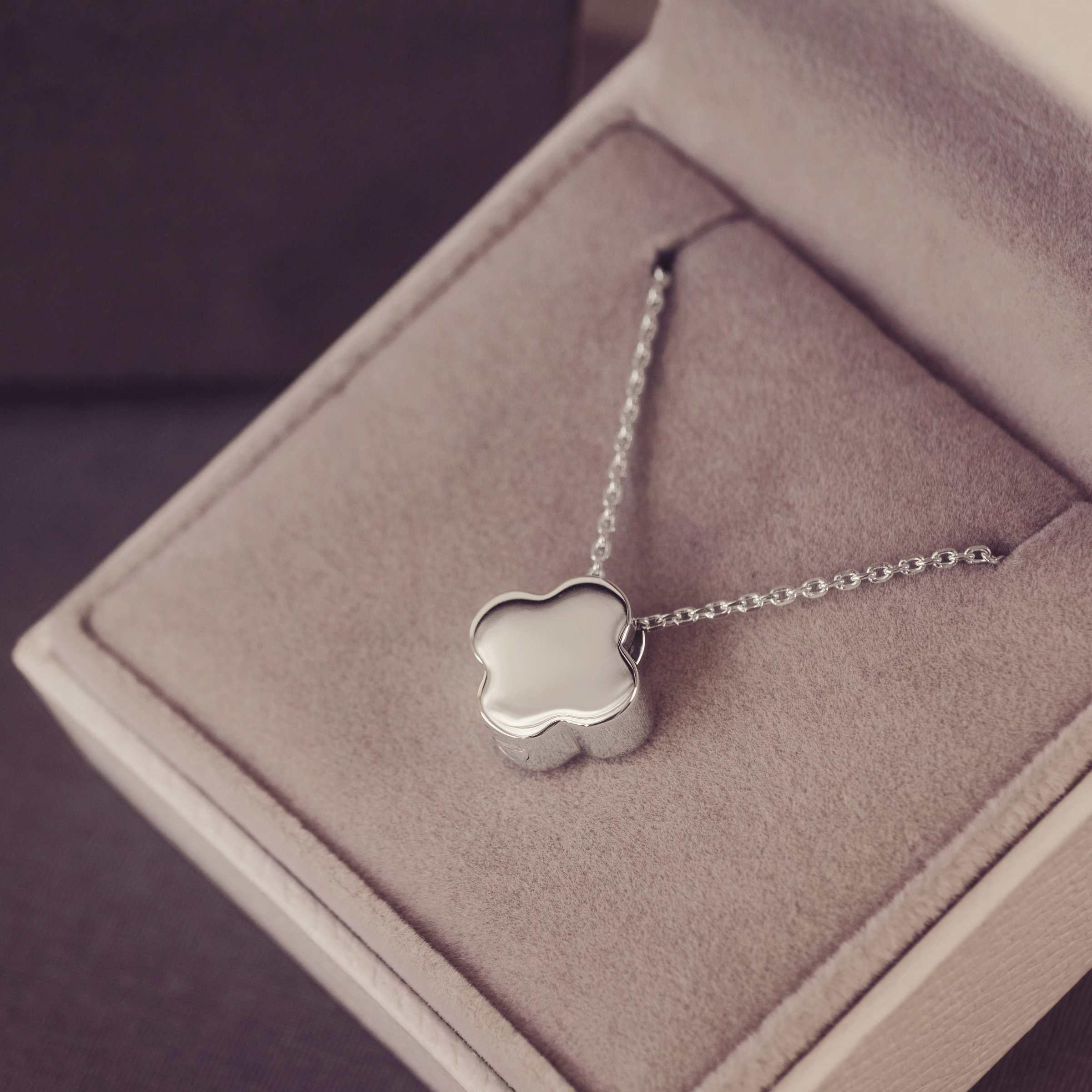 Silver necklace with a clover-shaped pendant in a jewellery box