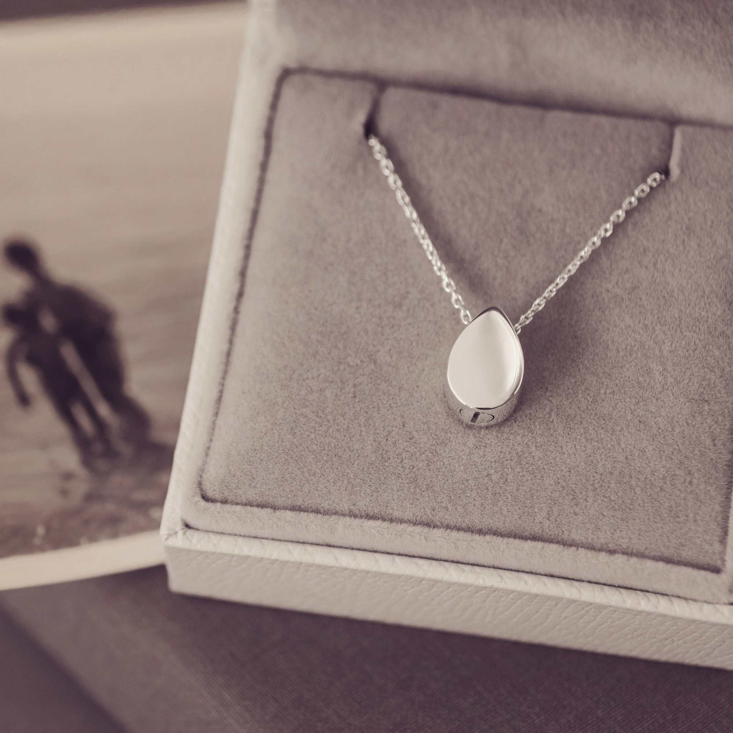 Silver Teardrop Necklace in a grey Jewellery box with a black and white photograph by its side