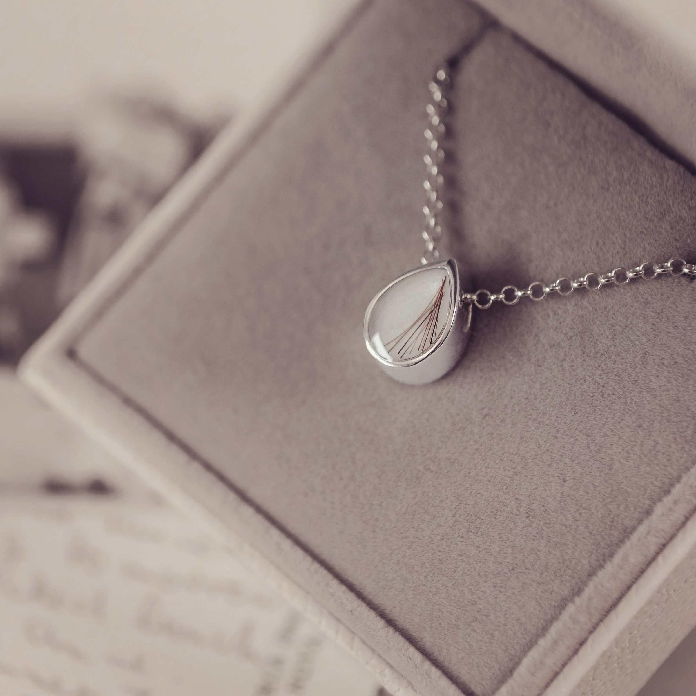 Silver necklace with a teardrop pendant in a jewellery box