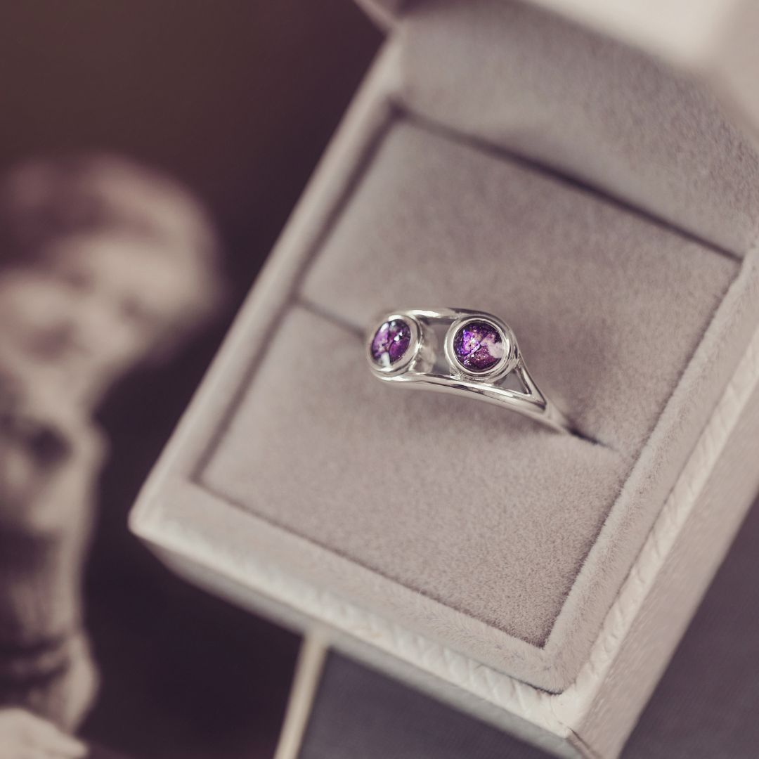 Silver ring with purple gemstones on a jewelry display box