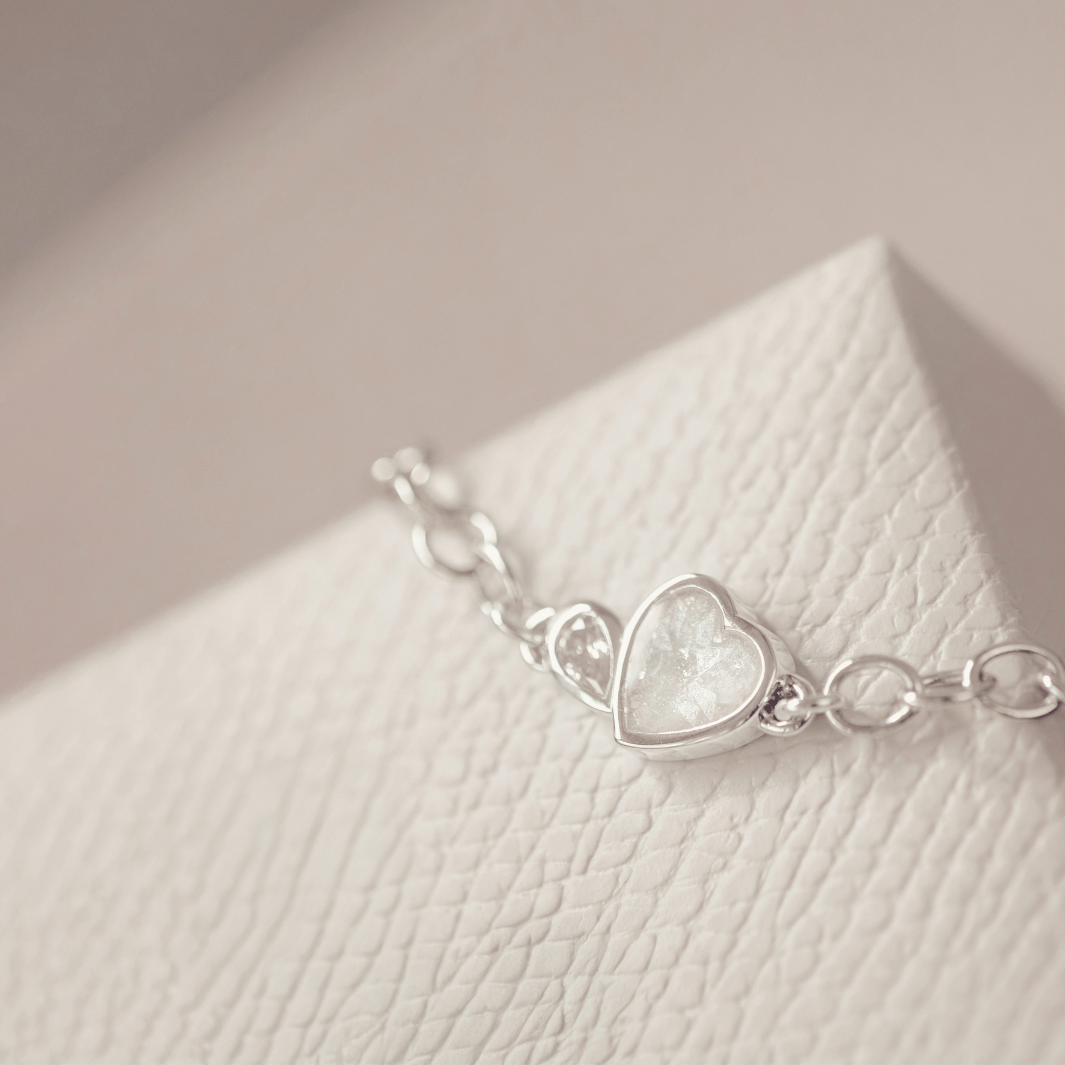 Silver bracelet with a heart-shaped setting on a textured surface
