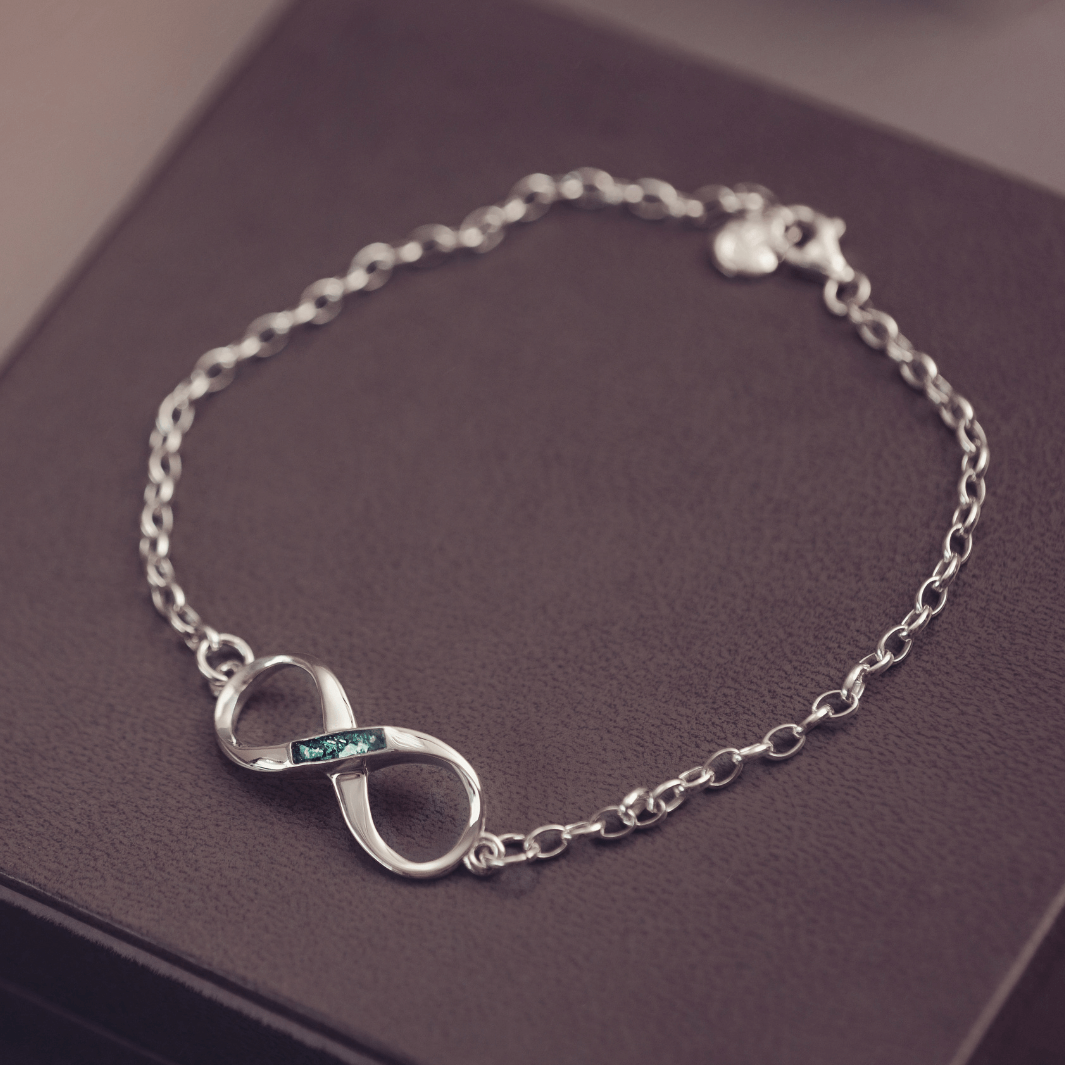 Silver bracelet with an infinity symbol on a purple surface