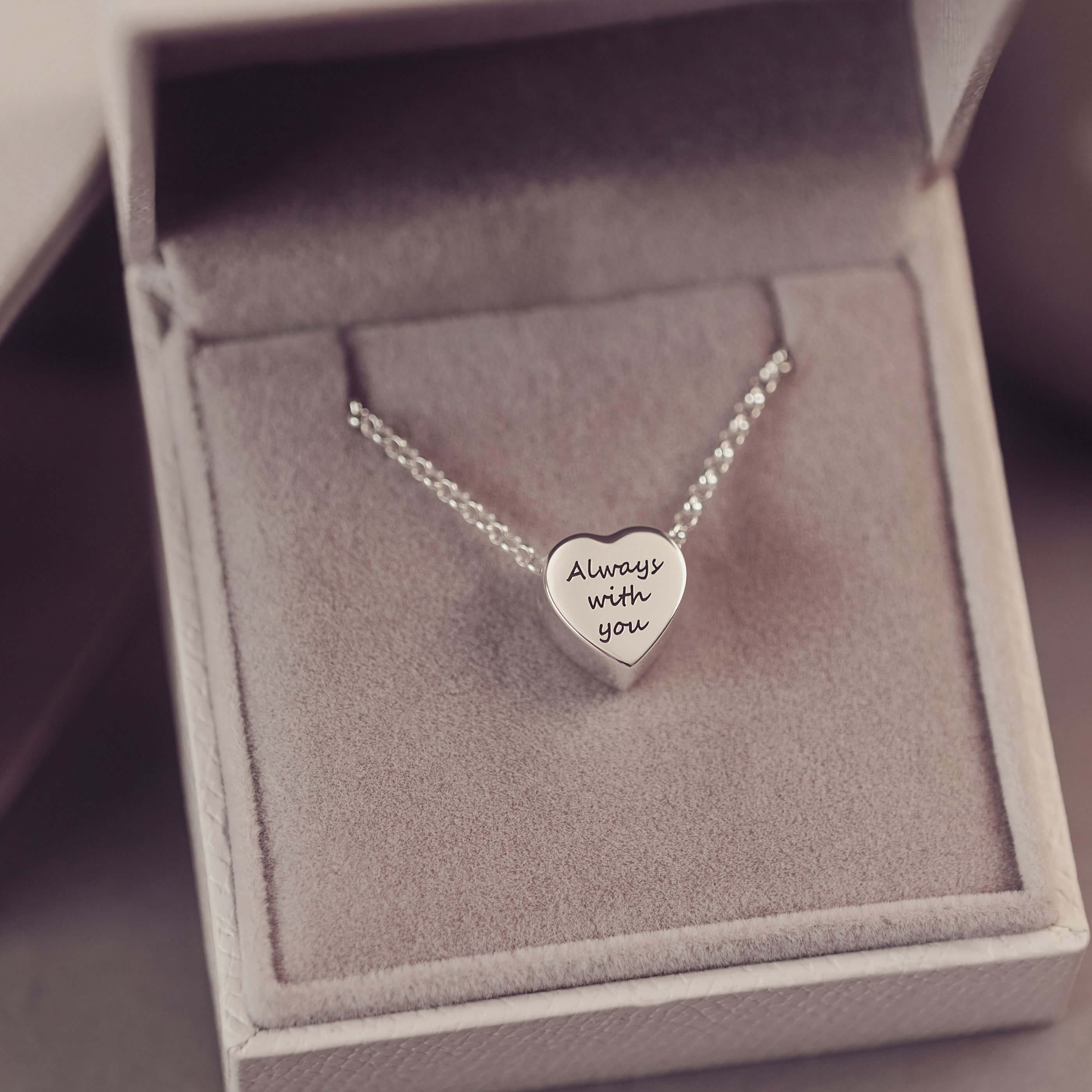 Silver heart-shaped necklace with 'Always with you' engraving in a box