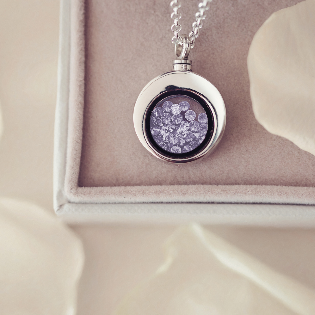 Silver necklace with a round pendant on a beige cushion