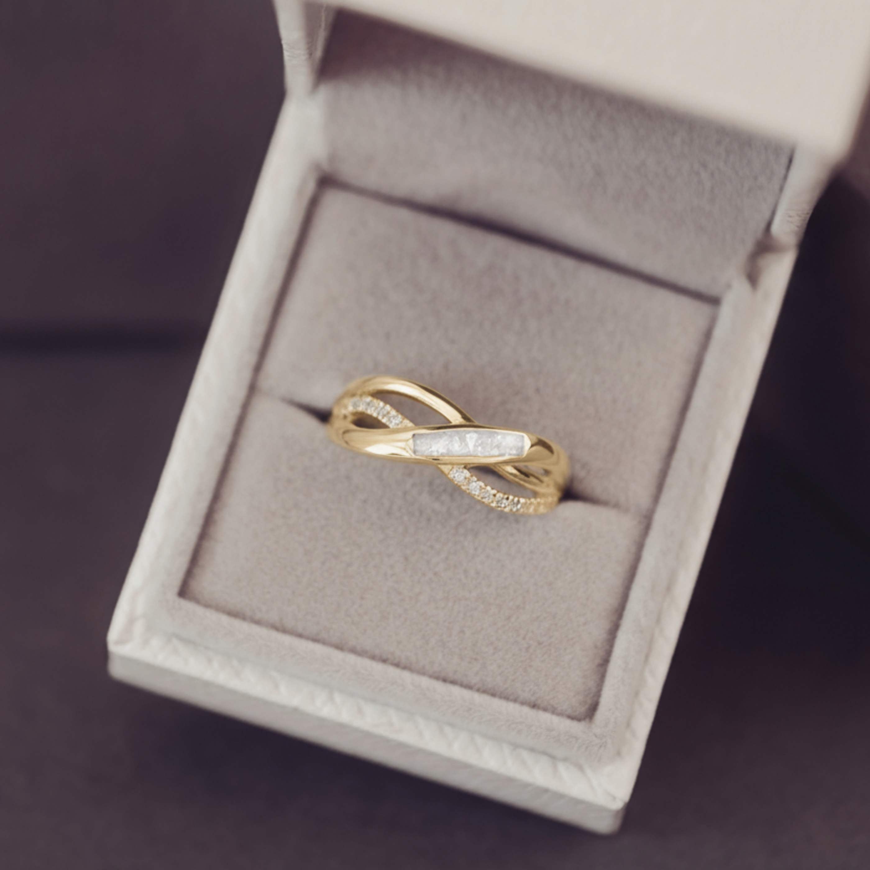Gold ring with diamonds in a jewelry box on a dark background