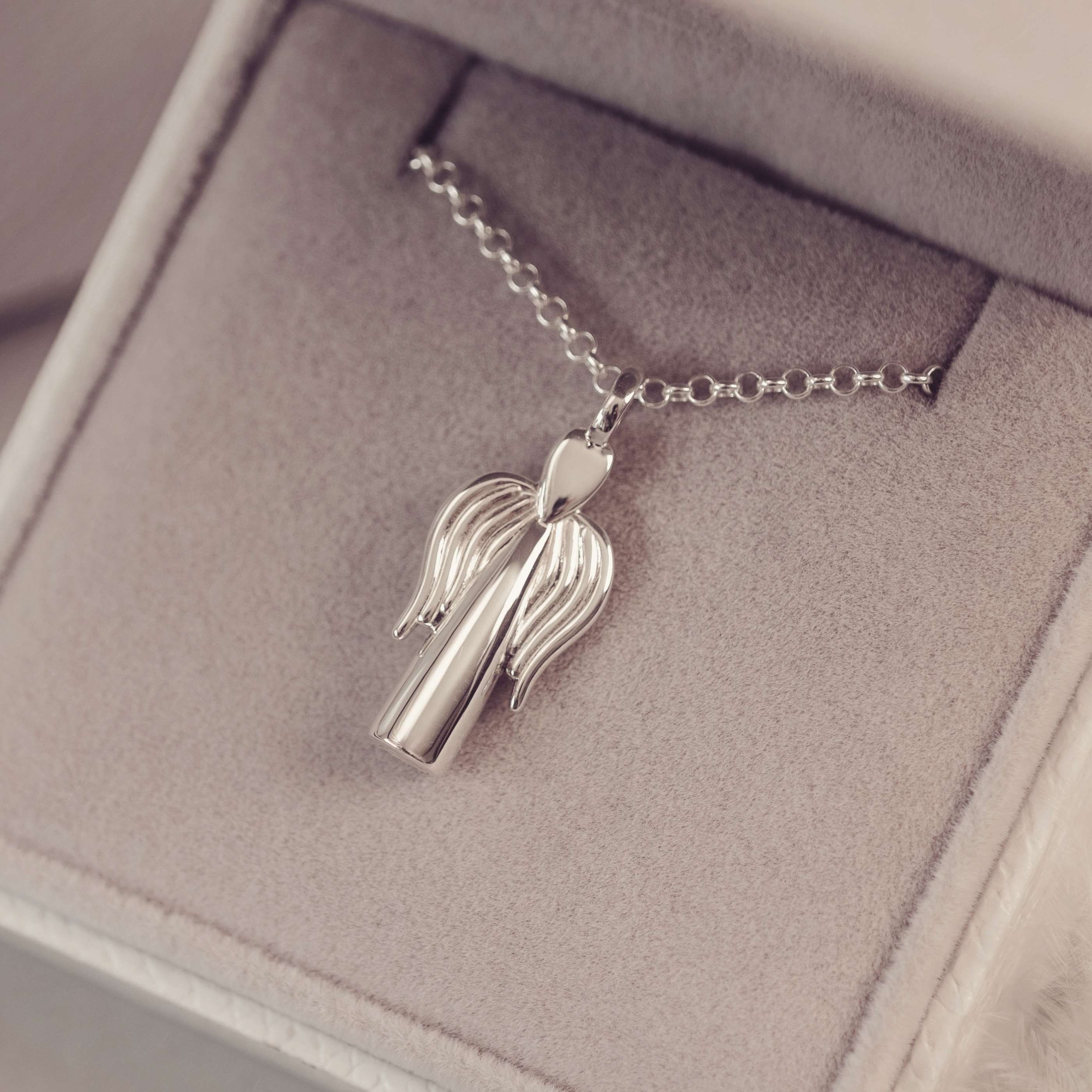 Silver necklace with a unique pendant on a soft gray background