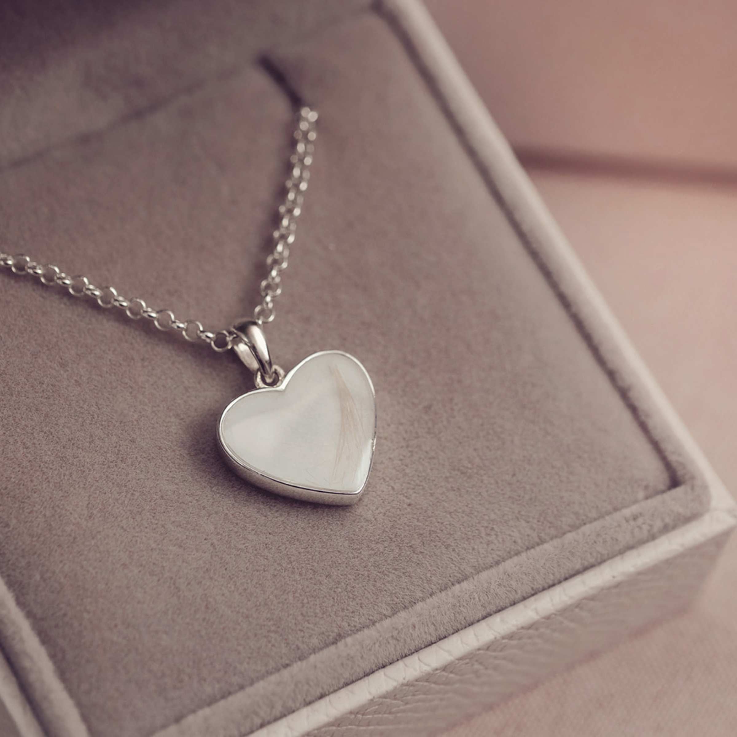 Silver heart-shaped pendant necklace on a soft surface