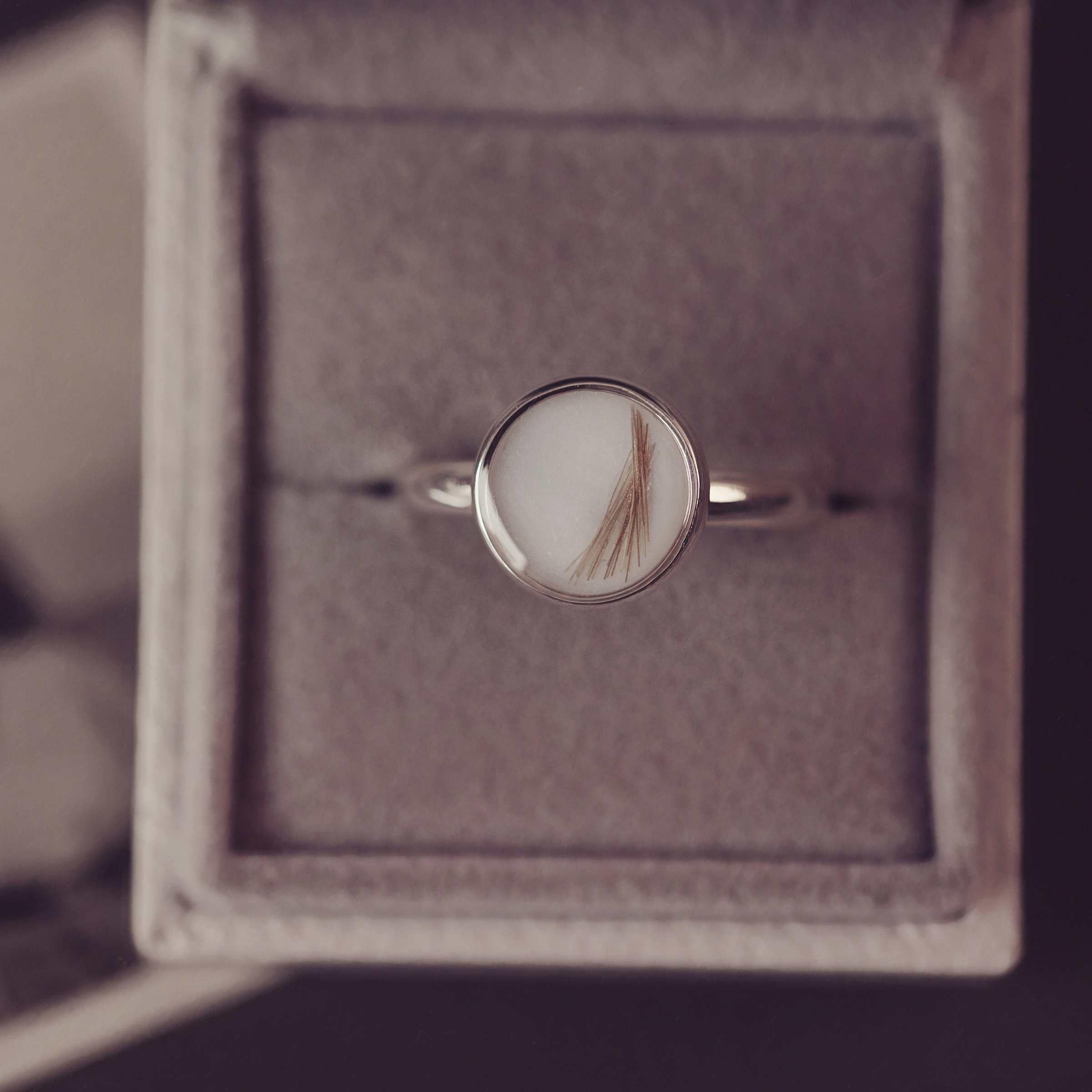 Silver ring with a circular stone in a jewellery box