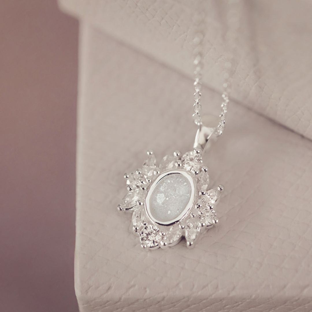 Silver necklace with a pendant on a soft pink background