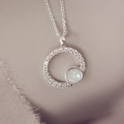 Silver necklace with a circular pendant on a soft background